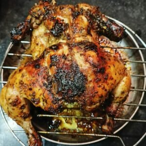 a cooked chicken sitting on top of a metal rack