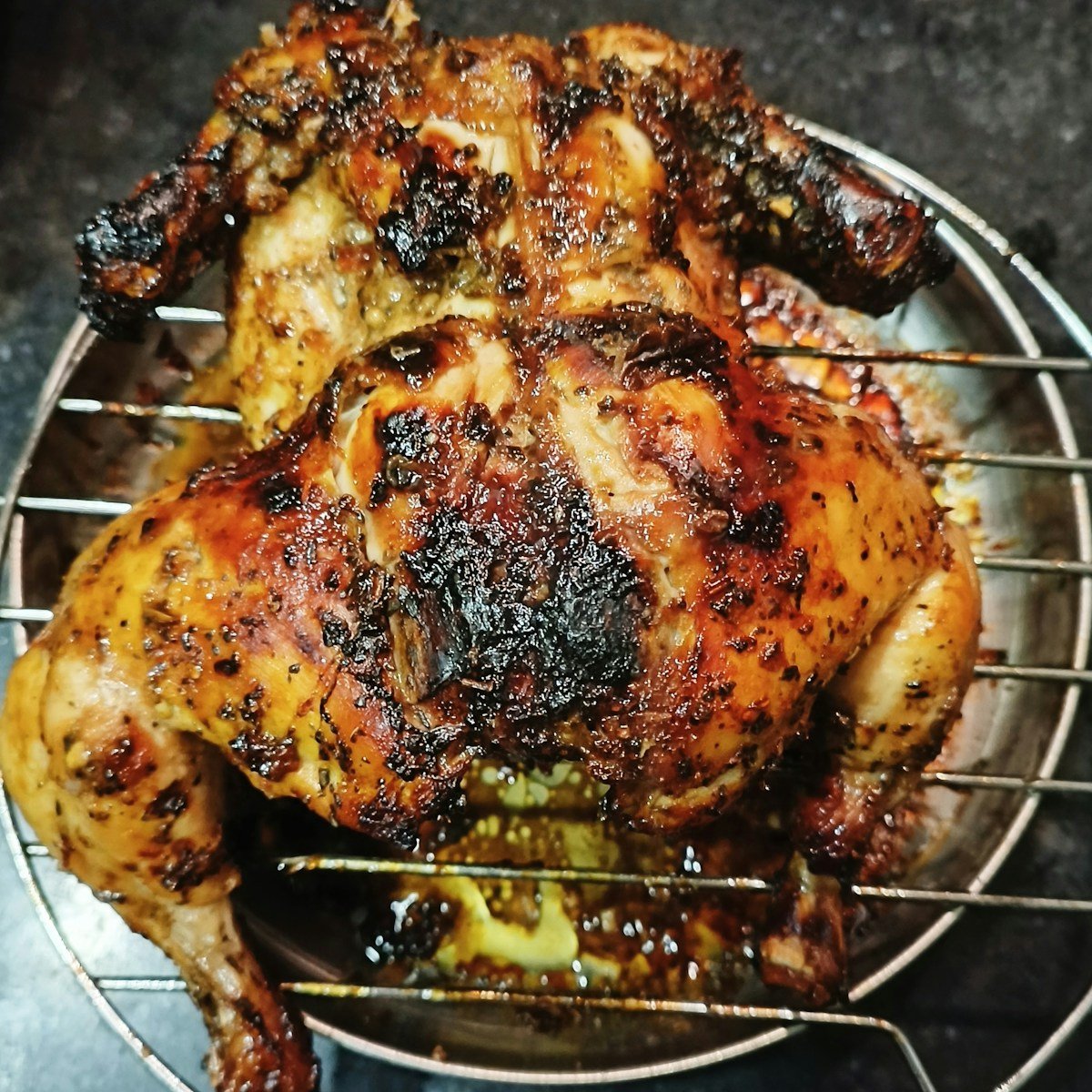 a cooked chicken sitting on top of a metal rack