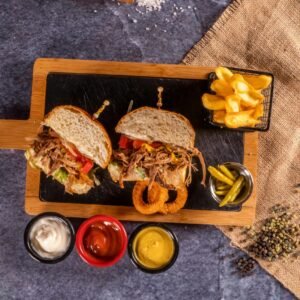 a wooden cutting board topped with two sandwiches