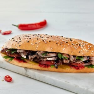 a large sandwich with meat, lettuce and tomatoes