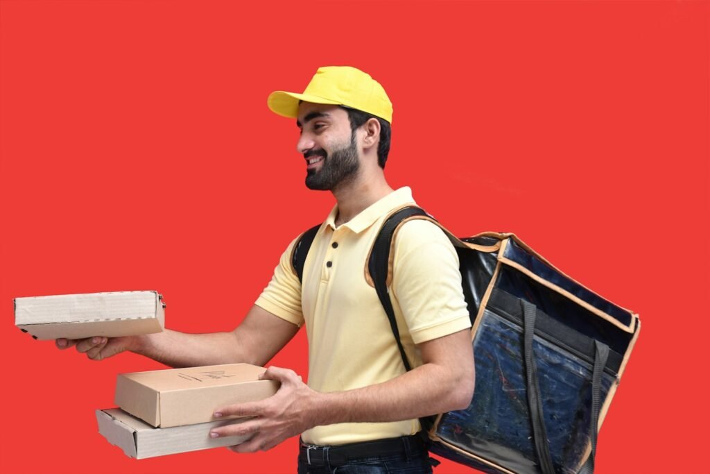 a man in a yellow hat holding a box